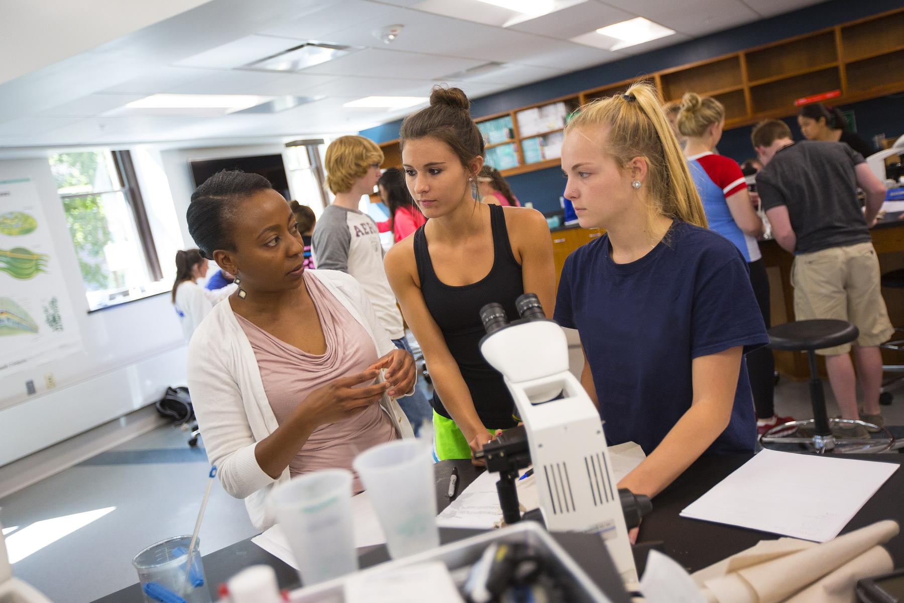 Students interact with an instructor in a lab on campus