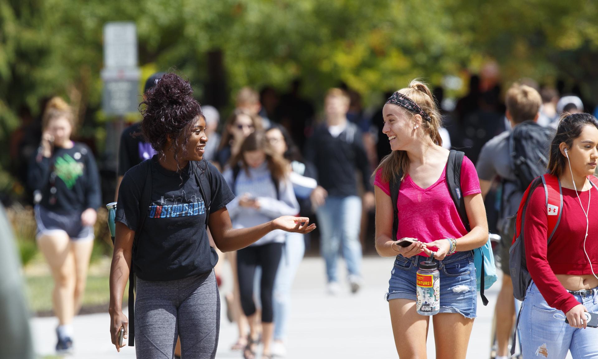 Students walk and laugh on campus