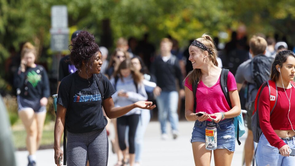 Students walk and laugh on campus